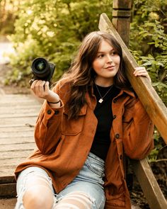 a woman sitting on the steps holding a camera