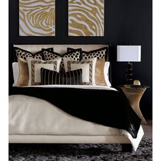 a black and gold bedroom with zebra prints on the wall above the bed, along with two lamps