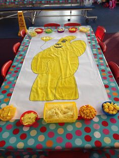 a table set up for a child's birthday party with a large yellow bear on it