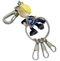 a keychain shaped like a cartoon character holding onto a pair of scissors with both hands