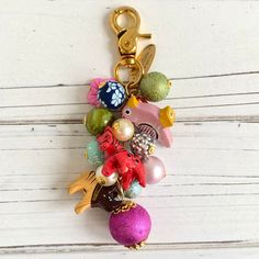 a keychain that has some ornaments hanging from it's side on a white wooden surface