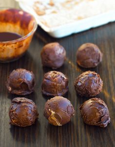 chocolate truffles are sitting on a table next to a bowl of dipping sauce