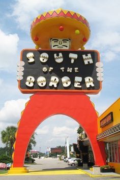 a sign that says south of the border in front of a building with a mexican hat on top