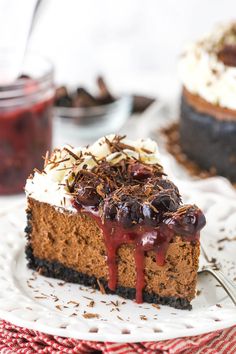 a slice of chocolate cheesecake with cherries and whipped cream on top is sitting on a white plate