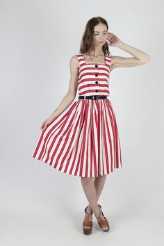 "Vintage 80s summer festival midi dress. Tailored tank bodice with button down front. Gathered elastic waist with sweeping skirt. Red and white striped cotton material. size estimate: M shoulders: - bust: 27\" - 36\" waist: 22\" - 34\" hips: - total length: 41\" * Visit the shop * https://www.etsy.com/shop/americanarchive Model is 5'9\" Belts and other accessories are not included." Red A-line Vintage Summer Dress, Retro A-line Dress For Day Out, Summer Vintage A-line Dress For Casual Occasions, Summer A-line Vintage Dress For Casual Wear, Retro Summer Midi Dress For A Day Out, Red 1950s Style Spring Dress, Summer Daywear Dresses With Full Skirt, Red Knee-length Vintage Summer Dress, Summer Midi Dress With Full Skirt For Daywear