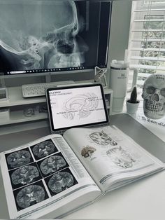 an open book sitting on top of a desk next to a computer monitor and keyboard