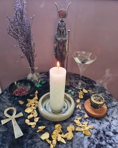 a candle is lit on a table with other items around it, including chips and wine glasses