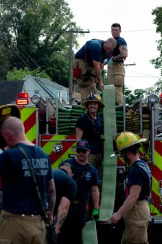 the firemen are getting ready to put out their hoses on top of the truck