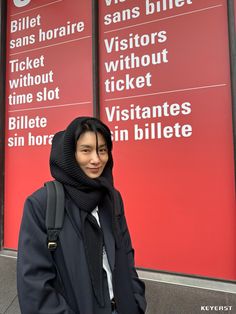 a woman standing in front of two red signs