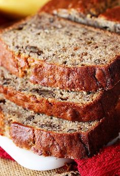 slices of banana bread sitting on top of a white plate next to a red towel