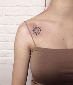 a woman with a sun tattoo on her shoulder