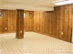 an empty room with wood paneling on the walls and carpeted floor is shown