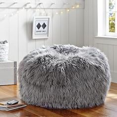 a living room filled with furniture and a large furry bean bag on top of a hard wood floor