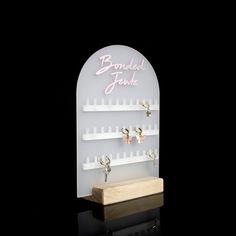 a display case with earrings on it and a sign that says bombied jewisha