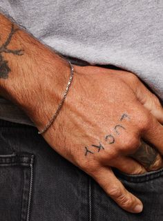 a man's hand with tattoos on it and the word fox tattooed on his left wrist