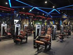 an indoor gym with rows of machines and lights