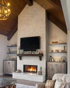 a living room with a fire place next to a tv on a wall above a fireplace