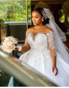 a woman in a wedding dress is walking down the stairs with her bouquet and veil on