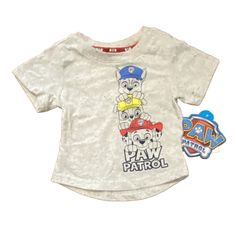 Get Ready For Some Adventure With This 18m Paw Patrol Shirt! Featuring Marshall And Chase From The Beloved Paw Patrol Series In A Solid Gray Color, This T-Shirt Is Perfect For Your Little One's Casual Everyday Wear. The Short Sleeves And Round Neckline With Pullover Closure Make It Easy To Dress Up Or Down. Made From A Comfortable Blend Of Polyester And Cotton, This Shirt Is Perfect For Walking, School, Or Any Other Everyday Activity. It Is Brand New With Tags And Comes In A Regular Fit Suitable Casual Tops With Character Print For Playtime, Playtime Graphic Tee With Character Print, Graphic Tee With Character Print For Playtime, Graphic Tee Tops With Character Print For Playtime, Cotton Tops With Character Print For Playwear, Pre-shrunk Cotton Tops For Playtime, Graphic Tee Shirt For Playtime With Short Sleeves, Short Sleeve Graphic Tee For Playtime, Short Sleeve Shirt With Character Print For Playtime