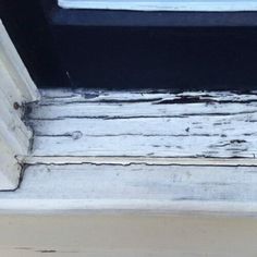 an old window sill with peeling paint on it