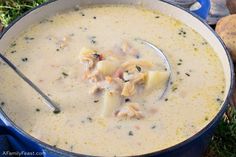 a blue pot filled with soup next to bread