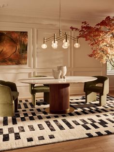 an elegant dining room with white walls and wood flooring is furnished with modern furniture