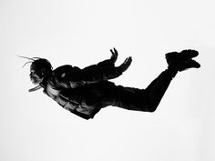 a man flying through the air while riding a skateboard in front of a white background