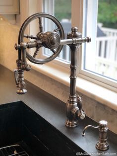 an old fashioned kitchen faucet in front of a window