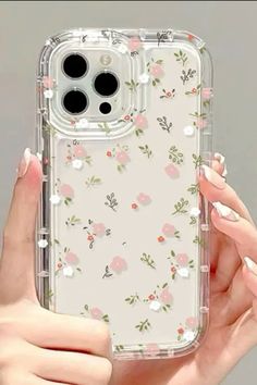 a woman holding up an iphone case with flowers on it, and the phone cover is clear