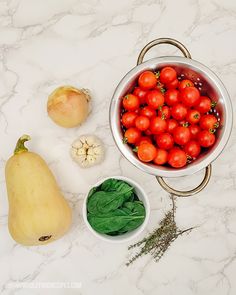 tomatoes, spinach and garlic on a marble counter top