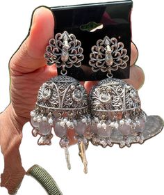 Eid Festival Chandbali Jhumkas, Chandbali Jhumkas For Eid, Eid Tilla Jhumkas, Eid Jhumkas With Tilla, Navratri Peacock Design Jhumkas, Eid Cutdana Danglers, Traditional Chandbali Jhumkas With Bells, Festive Heavy Silver Jhumkas, Bollywood Style Intricate Design Jhumkas