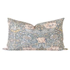 a blue and pink pillow with an intricate floral design on the front, sitting on a white background