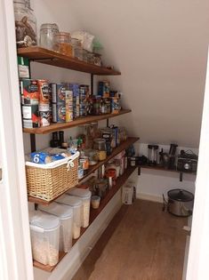 an open pantry with lots of food and containers on the shelves in front of it