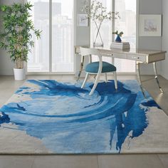 a blue and white area rug with an abstract design on it in front of a window