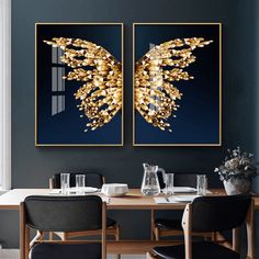 two paintings hanging on the wall above a dining room table