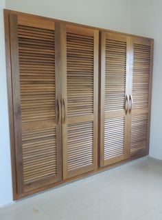 a room with wooden shutters on the doors and tile flooring in front of it