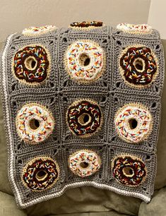 a crocheted blanket with doughnuts on it is sitting on a couch