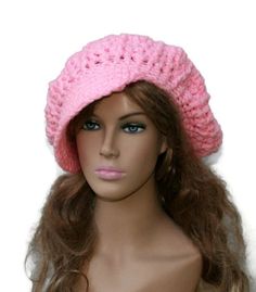 a mannequin head wearing a pink crochet hat on top of a wig