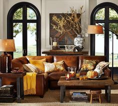 a living room filled with lots of furniture and large windows in front of the wall