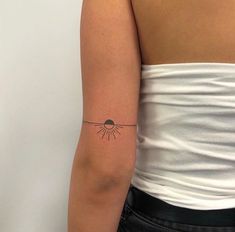 a woman with a small sun tattoo on her arm