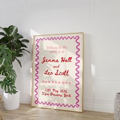 a framed wedding card next to a potted plant