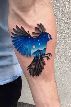 a blue bird tattoo on the arm