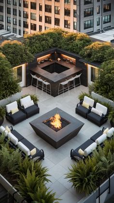 an outdoor fire pit surrounded by seating and plants in the middle of a large courtyard