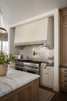 a kitchen with marble counter tops and an island in the middle, surrounded by wooden cabinets