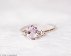 Sterling silver amethyst engagement ring with 2 small pearls... A lovely design as an engagement ring or a unique promise ring, gift for women who love simple & elegant style ♡► FEATURES;Gemstone Size: 6*8mm pear cut Amethyst and 2*2mm pearls...Material Options: 925k Sterling Silver, Rose Gold Filled, Yellow Gold Filled. 14K Solid Gold Options are available (Please contact me about the price).► HOW TO ORDER;Please select your preffered size and material from the menu while adding to card.Ple White Amethyst Wedding Ring In Fine Jewelry Style, Fine Jewelry White Amethyst Wedding Ring, White Amethyst Wedding Ring Fine Jewelry, White Amethyst Ring For Anniversary, Elegant White Amethyst Ring Gift, Elegant White Amethyst Wedding Ring, Elegant Three Stone Amethyst Ring As Gift, Elegant Three Stone Amethyst Ring For Gift, Delicate Amethyst Gemstone Ring For Anniversary