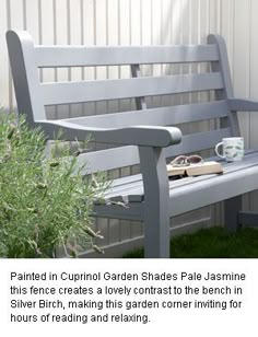 a wooden bench sitting next to a potted plant on top of a grass covered field