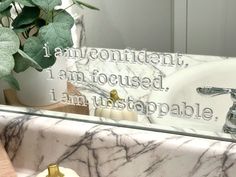 a bathroom sink with a marble counter top and mirror above it that says, i am not