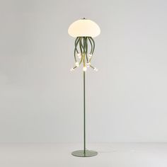 a floor lamp with an octopus design on the base and lights attached to it's sides