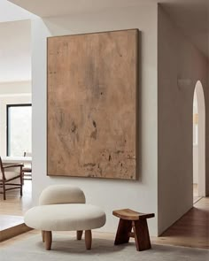 a living room with a large painting on the wall and two stools in front of it