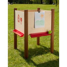 a wooden bench sitting in the middle of a field with a sign on it's back